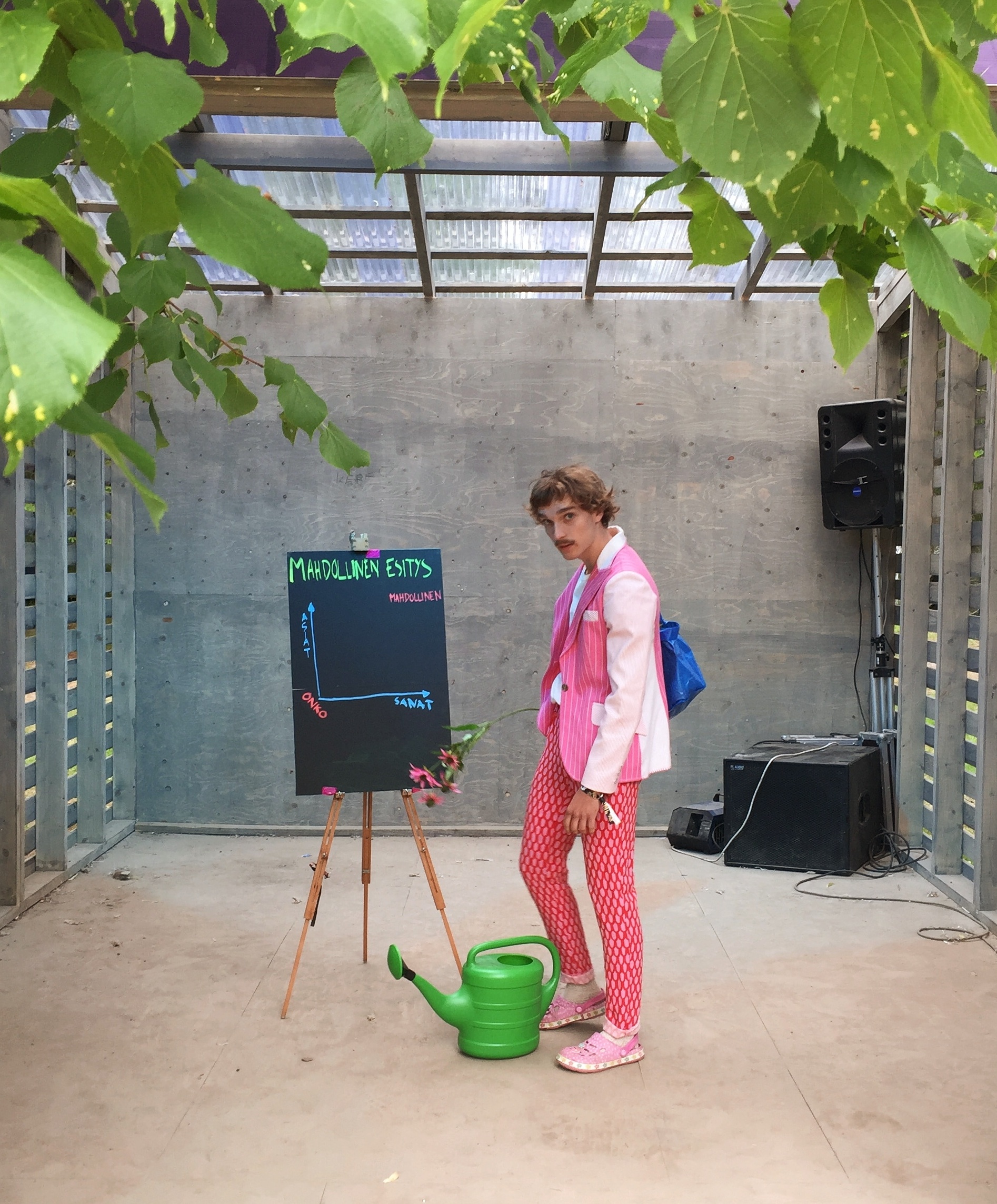 A person standing in a porch next to a watering can