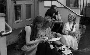 Nuoria ihmisiä istuu portailla