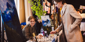 kaksi nuorta henkilö taideteosten äärellä